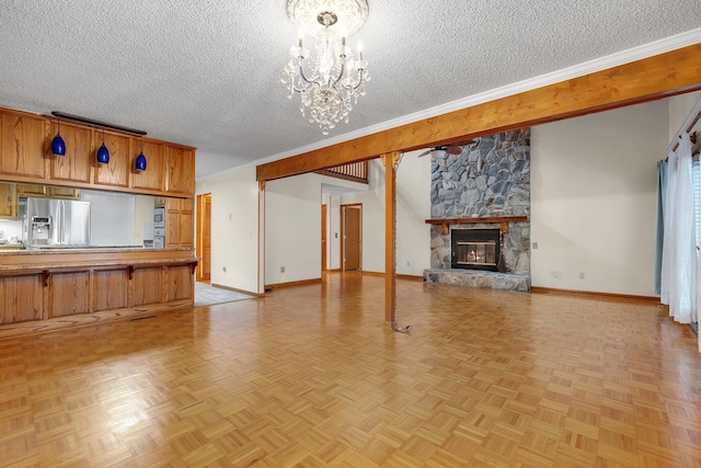414 Tharpe Cir, Quincy, FL 32351 - unfurnished living room featuring a chandelier, a textured ceiling, baseboards, a stone fireplace, and crown molding