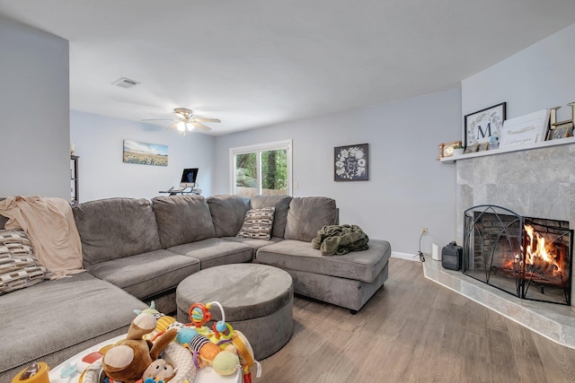 2401 Lanrell Dr, Tallahassee, FL 32303 - living room featuring a warm lit fireplace, wood finished floors, ceiling fan, and baseboards