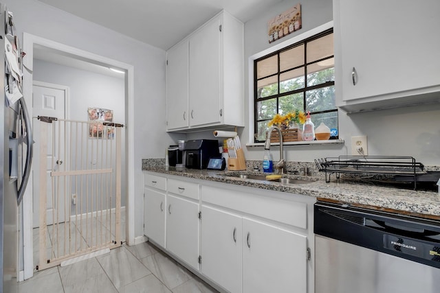 2401 Lanrell Dr, Tallahassee, FL 32303 - kitchen featuring stainless steel appliances, a sink, white cabinetry, and light stone counters