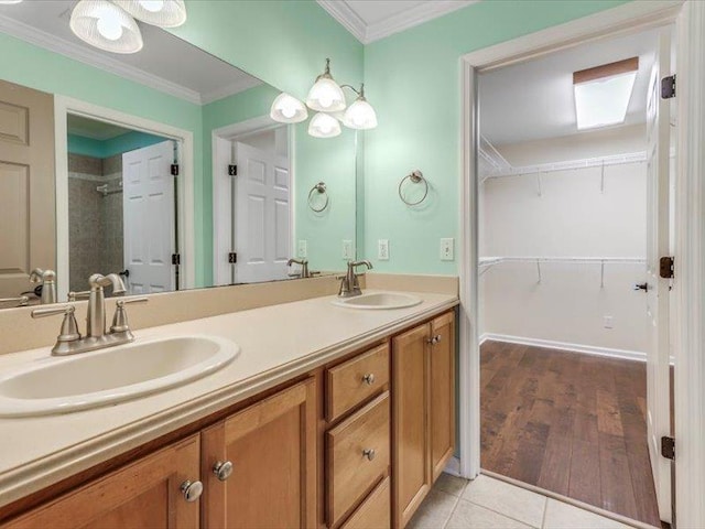 bathroom with tile patterned floors, ornamental molding, and vanity