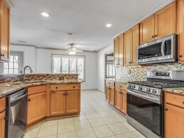 kitchen featuring stainless steel appliances, light stone countertops, decorative backsplash, ornamental molding, and kitchen peninsula