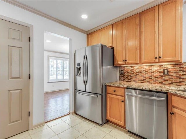 kitchen with light stone countertops, ornamental molding, backsplash, light tile patterned floors, and appliances with stainless steel finishes