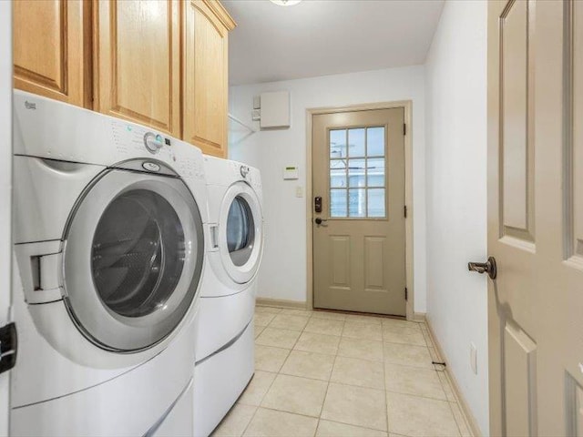 washroom featuring light tile patterned flooring, separate washer and dryer, and cabinets