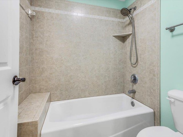 bathroom featuring tiled shower / bath and toilet