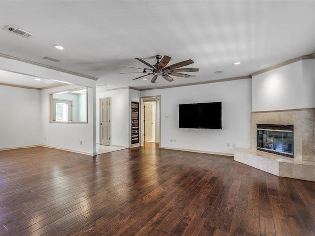 unfurnished living room with ceiling fan, a premium fireplace, dark hardwood / wood-style floors, and ornamental molding