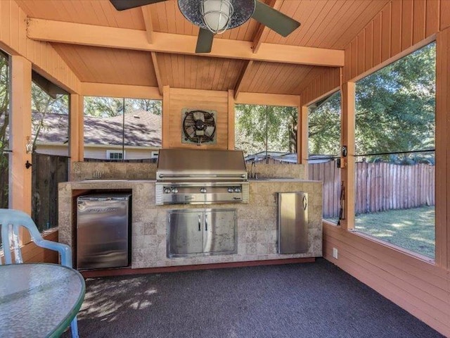 unfurnished sunroom featuring ceiling fan, vaulted ceiling with beams, and wooden ceiling