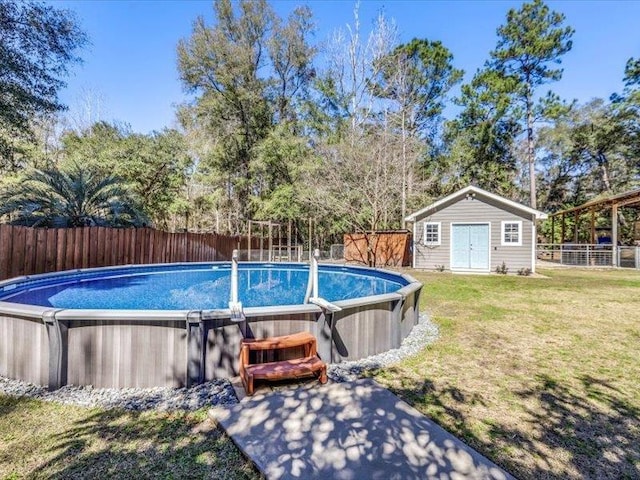 view of swimming pool featuring a lawn and a shed