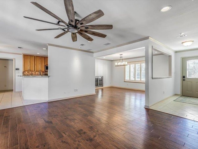 unfurnished living room featuring crown molding, light hardwood / wood-style floors, and ceiling fan with notable chandelier