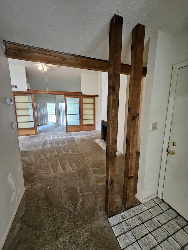 interior space with beamed ceiling, carpet floors, and a textured ceiling