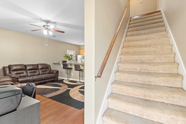 stairway featuring hardwood / wood-style flooring and ceiling fan