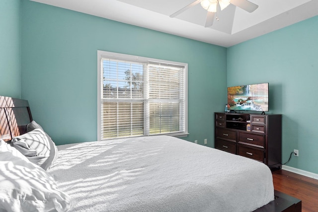 bedroom with dark hardwood / wood-style flooring and ceiling fan