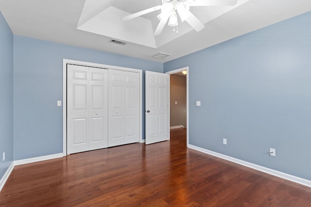 unfurnished bedroom featuring dark wood-type flooring, ceiling fan, and a closet