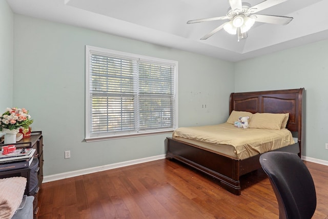 bedroom with dark hardwood / wood-style flooring and ceiling fan