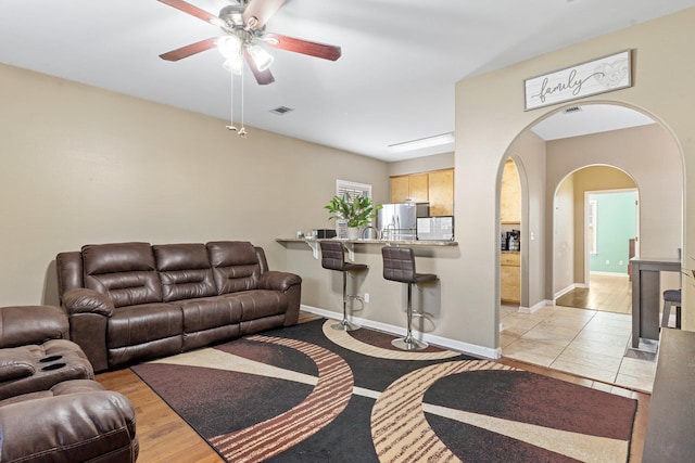 living room featuring light hardwood / wood-style flooring and ceiling fan