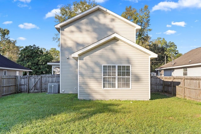 rear view of property featuring central AC and a yard