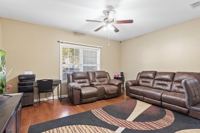 living room featuring dark wood-type flooring and ceiling fan