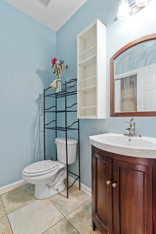 bathroom with vanity, tile patterned floors, and toilet