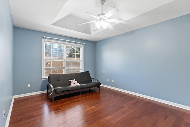 living area featuring ceiling fan and dark hardwood / wood-style floors