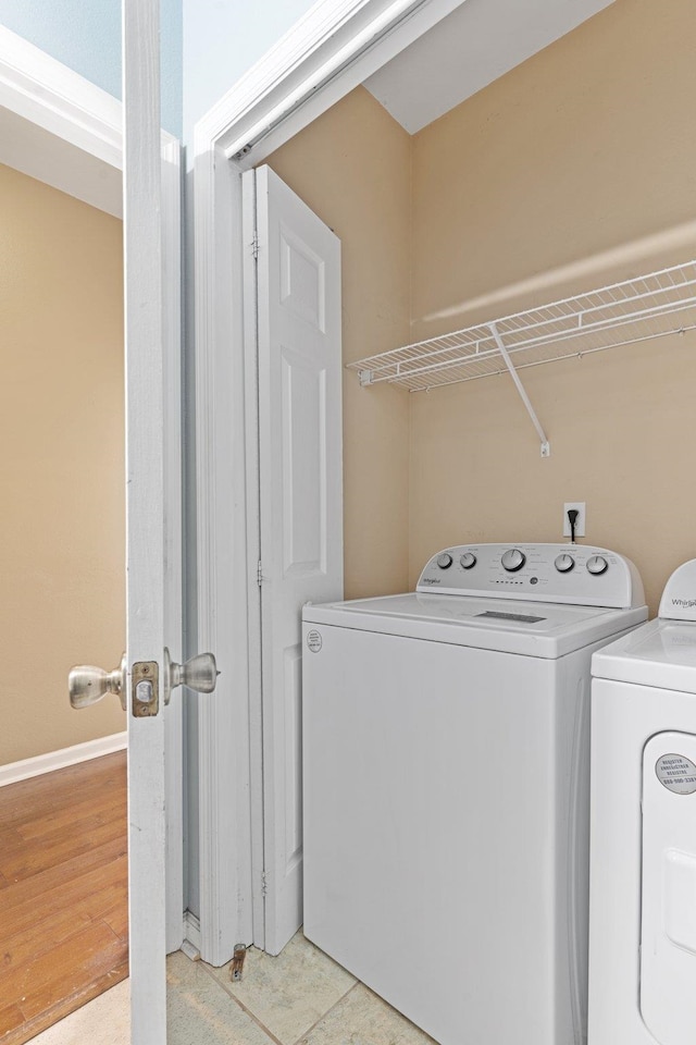 laundry room featuring washer and clothes dryer and light wood-type flooring