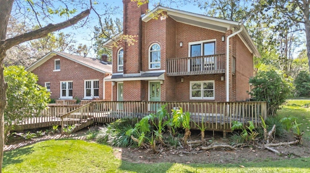 rear view of property featuring a chimney and brick siding