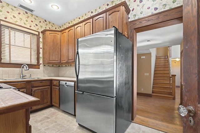 kitchen featuring a sink, visible vents, wallpapered walls, and appliances with stainless steel finishes