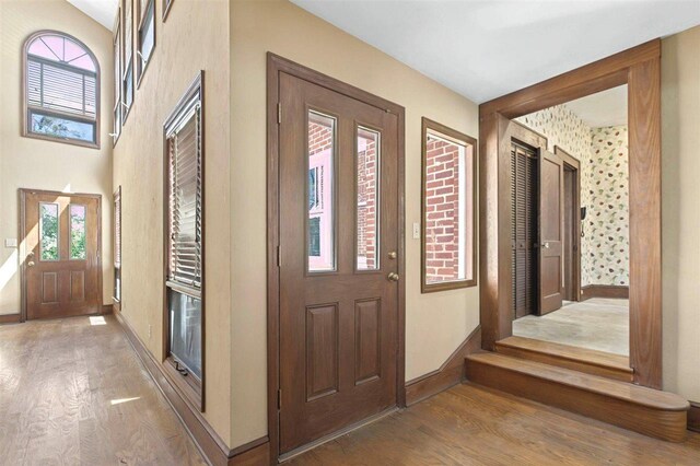 foyer featuring baseboards and wood finished floors