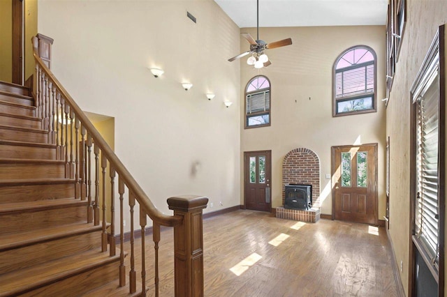 entryway featuring wood finished floors, baseboards, stairs, and a wealth of natural light