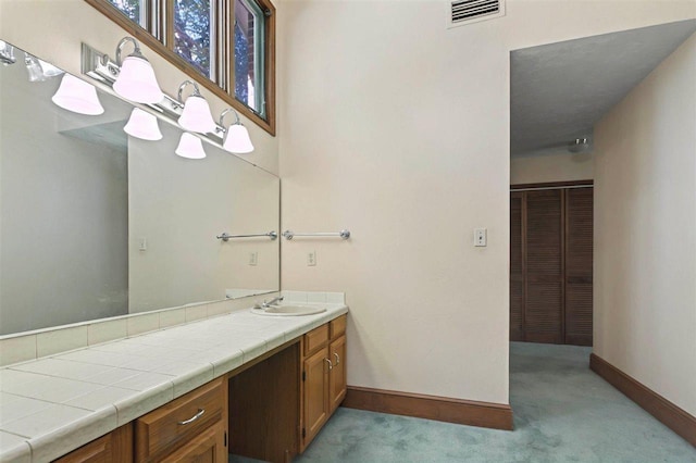 bathroom with baseboards, visible vents, and vanity