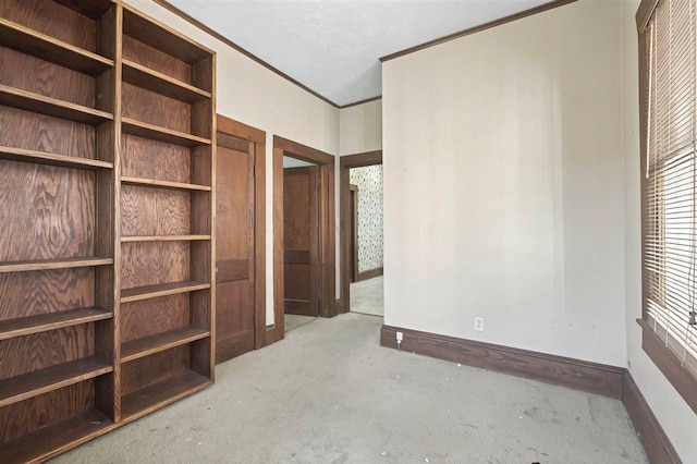 unfurnished bedroom with carpet, baseboards, and crown molding