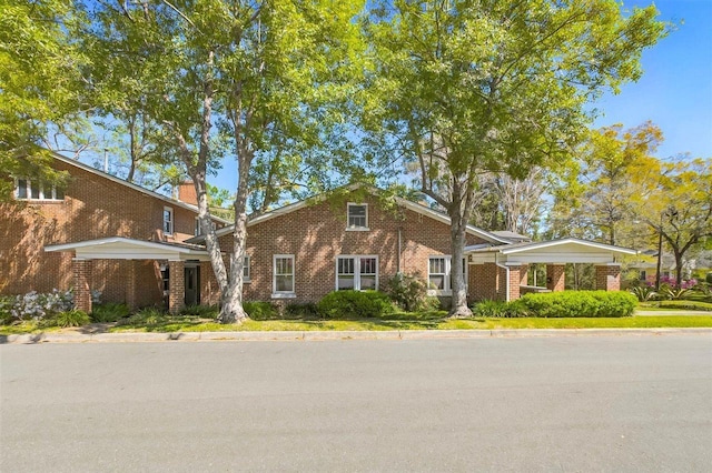view of front of house featuring brick siding and a chimney