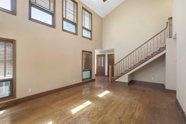 foyer entrance with baseboards, stairs, wood finished floors, and plenty of natural light