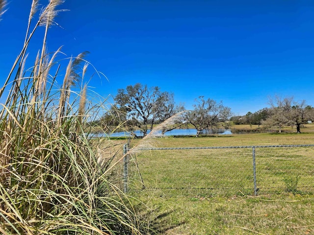 view of yard featuring a water view and fence