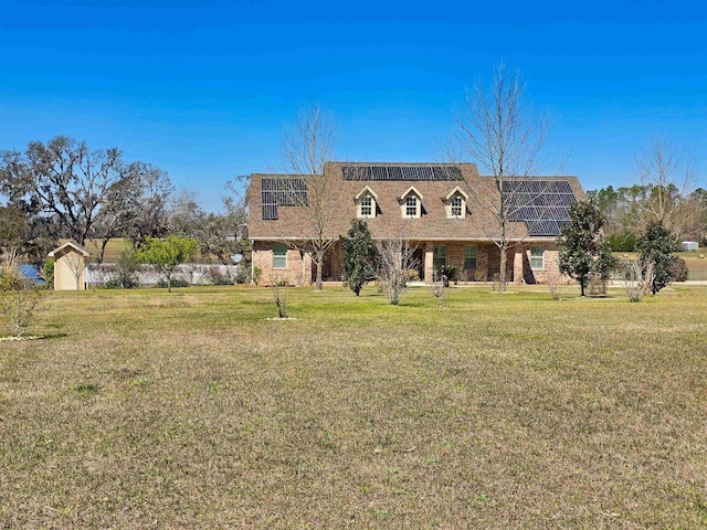 view of front of home featuring solar panels, a front lawn, and brick siding