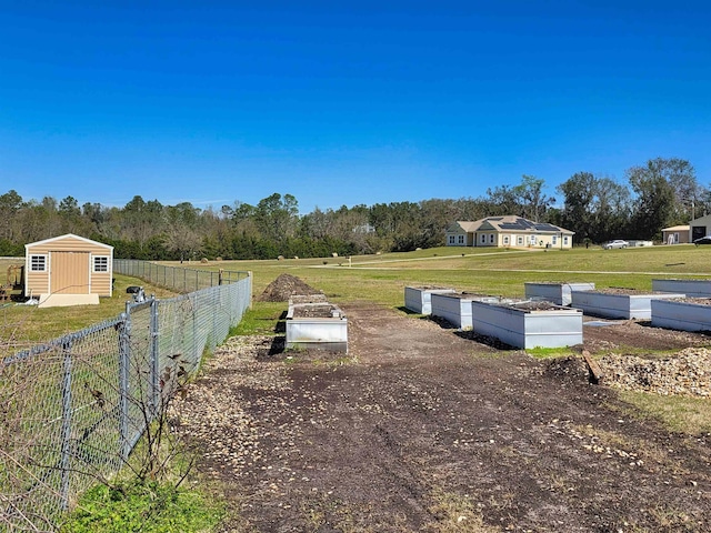 view of yard with an outbuilding, a rural view, and fence