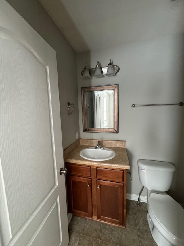 bathroom featuring tile patterned flooring, vanity, and toilet