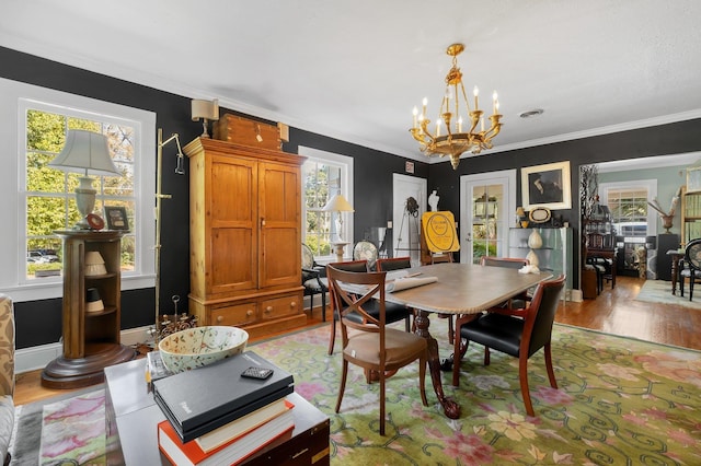 dining room featuring light hardwood / wood-style flooring, ornamental molding, and a chandelier