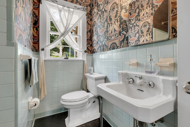 bathroom featuring tile walls, sink, and toilet
