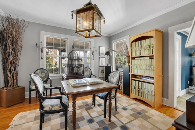 dining room with crown molding, plenty of natural light, and light wood-type flooring