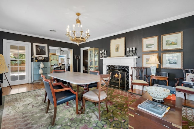 dining room with an inviting chandelier, ornamental molding, and hardwood / wood-style flooring