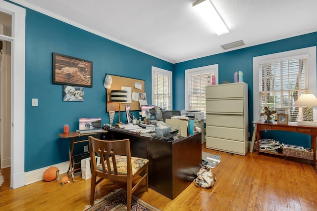 office with ornamental molding, a healthy amount of sunlight, and light wood-type flooring