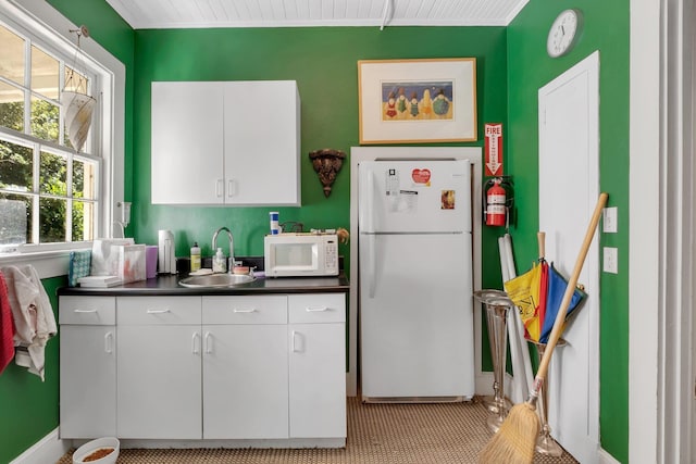kitchen with sink, white appliances, and white cabinets