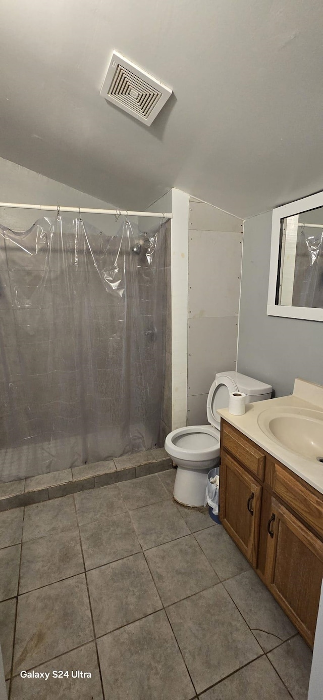 bathroom with tile patterned floors, vanity, toilet, and curtained shower