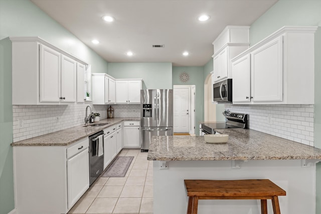 1652 Eagles Watch Way, Tallahassee, FL 32312 - kitchen featuring stainless steel appliances, a peninsula, decorative backsplash, white cabinets, and recessed lighting
