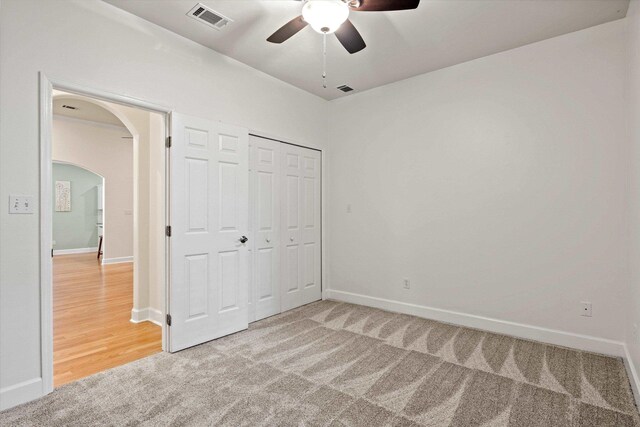 1652 Eagles Watch Way, Tallahassee, FL 32312 - unfurnished bedroom featuring light colored carpet, arched walkways, a closet, and a ceiling fan