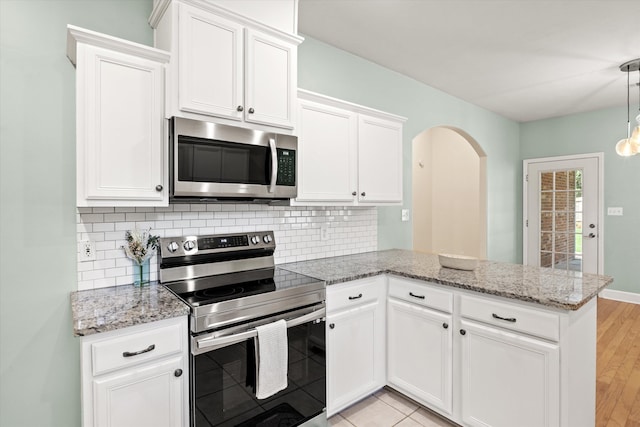1652 Eagles Watch Way, Tallahassee, FL 32312 - kitchen with appliances with stainless steel finishes, a peninsula, decorative backsplash, white cabinets, and light stone counters
