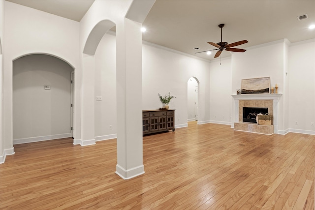 1652 Eagles Watch Way, Tallahassee, FL 32312 - unfurnished living room featuring ceiling fan, arched walkways, light wood-style flooring, a fireplace, and recessed lighting