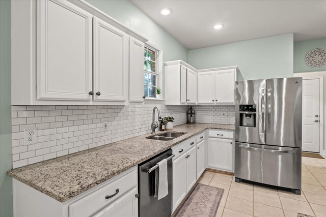 1652 Eagles Watch Way, Tallahassee, FL 32312 - kitchen featuring appliances with stainless steel finishes, white cabinetry, light stone countertops, decorative backsplash, and light tile patterned floors