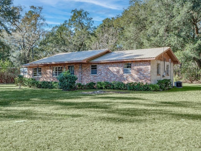 view of front of property with central AC unit and a front yard