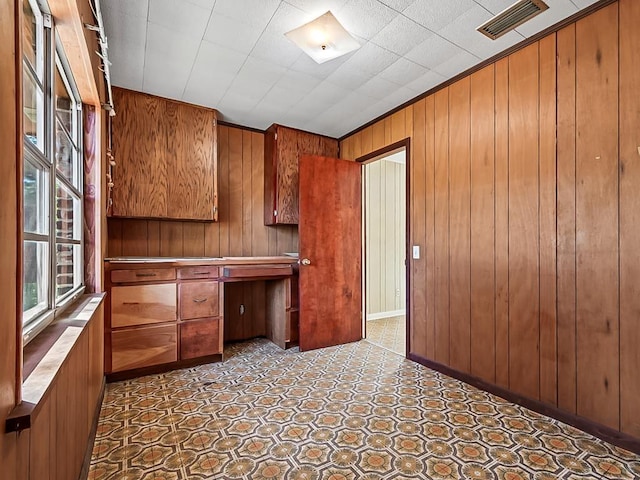 unfurnished office featuring wood walls