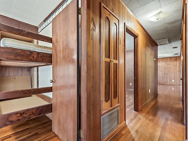 corridor with wooden walls and light hardwood / wood-style flooring